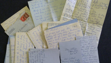 A collection of beautifully handwritten letters in front of black background.