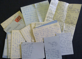 A collection of beautifully handwritten letters in front of black background.