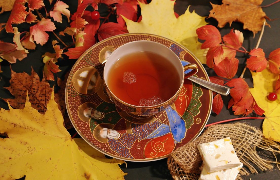 A mug of tea in a highly decorated cup and saucer.