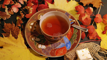A mug of tea in a highly decorated cup and saucer.