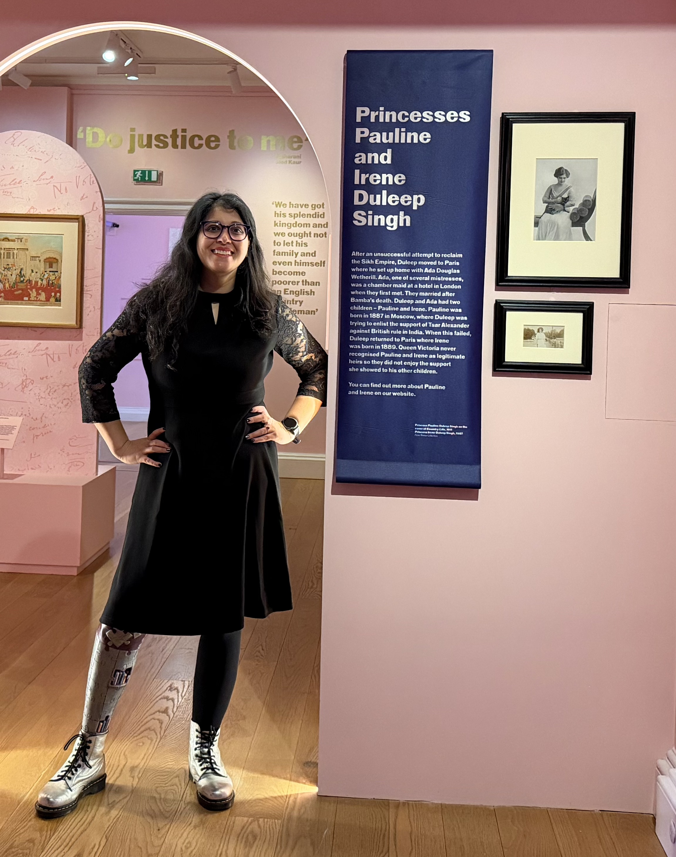 Asian woman stood under an archway in an exhibition.