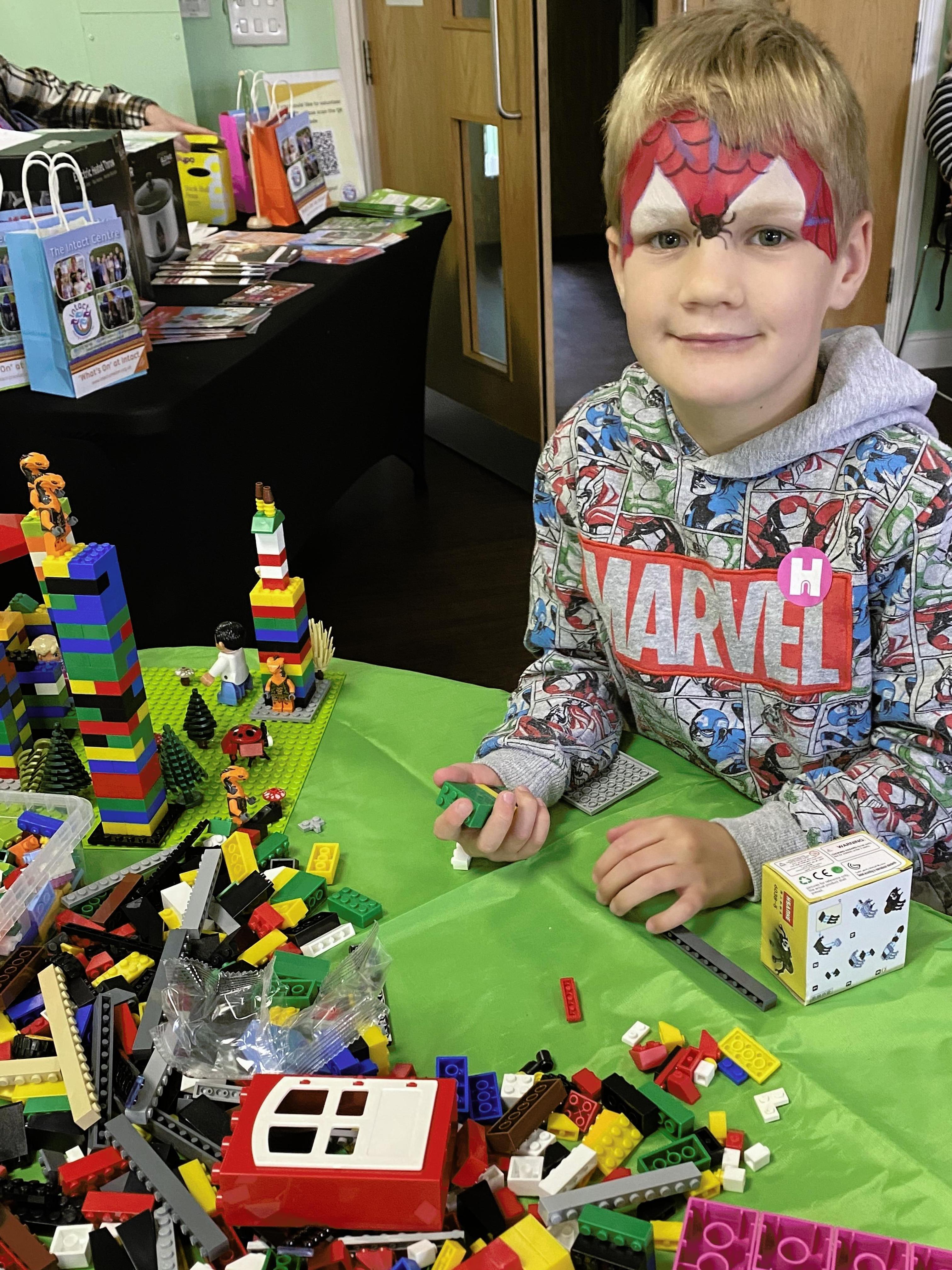Boy playing with Lego at a table.