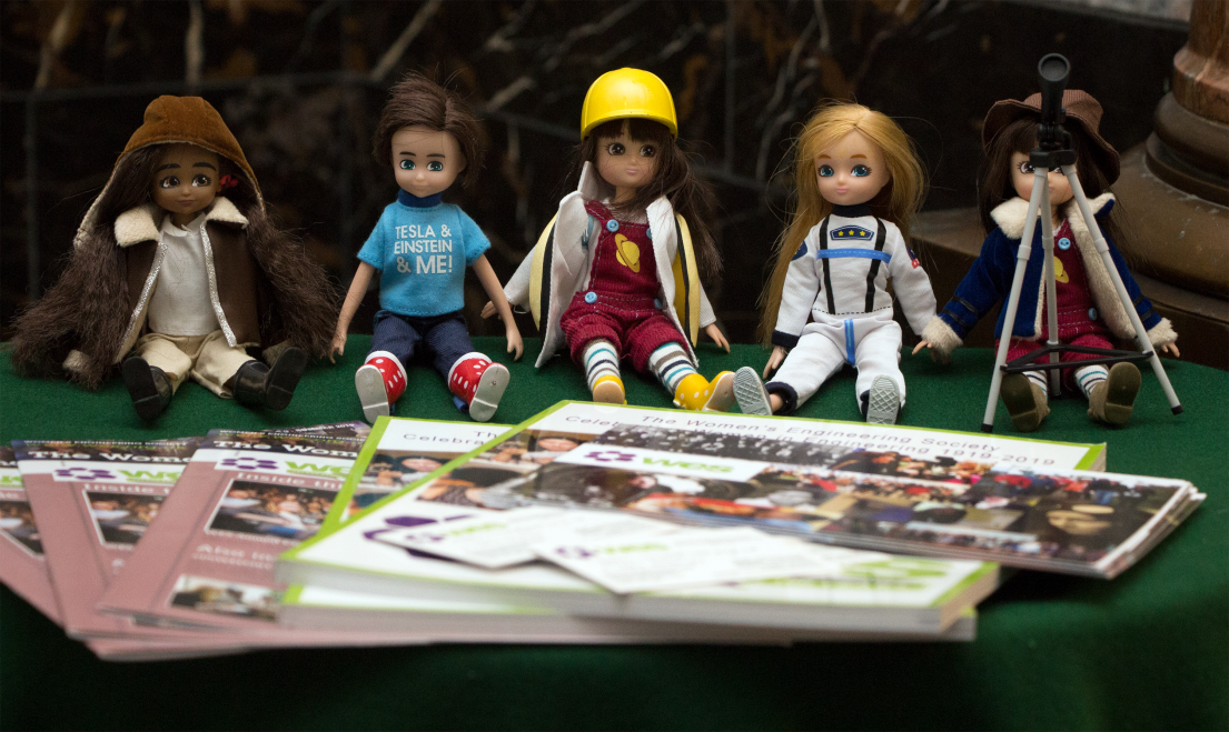 A collection of 5 small dolls - Lottie Dolls - who are dressed representing different careers a women could have - wearing planet dungarees, hard hats
