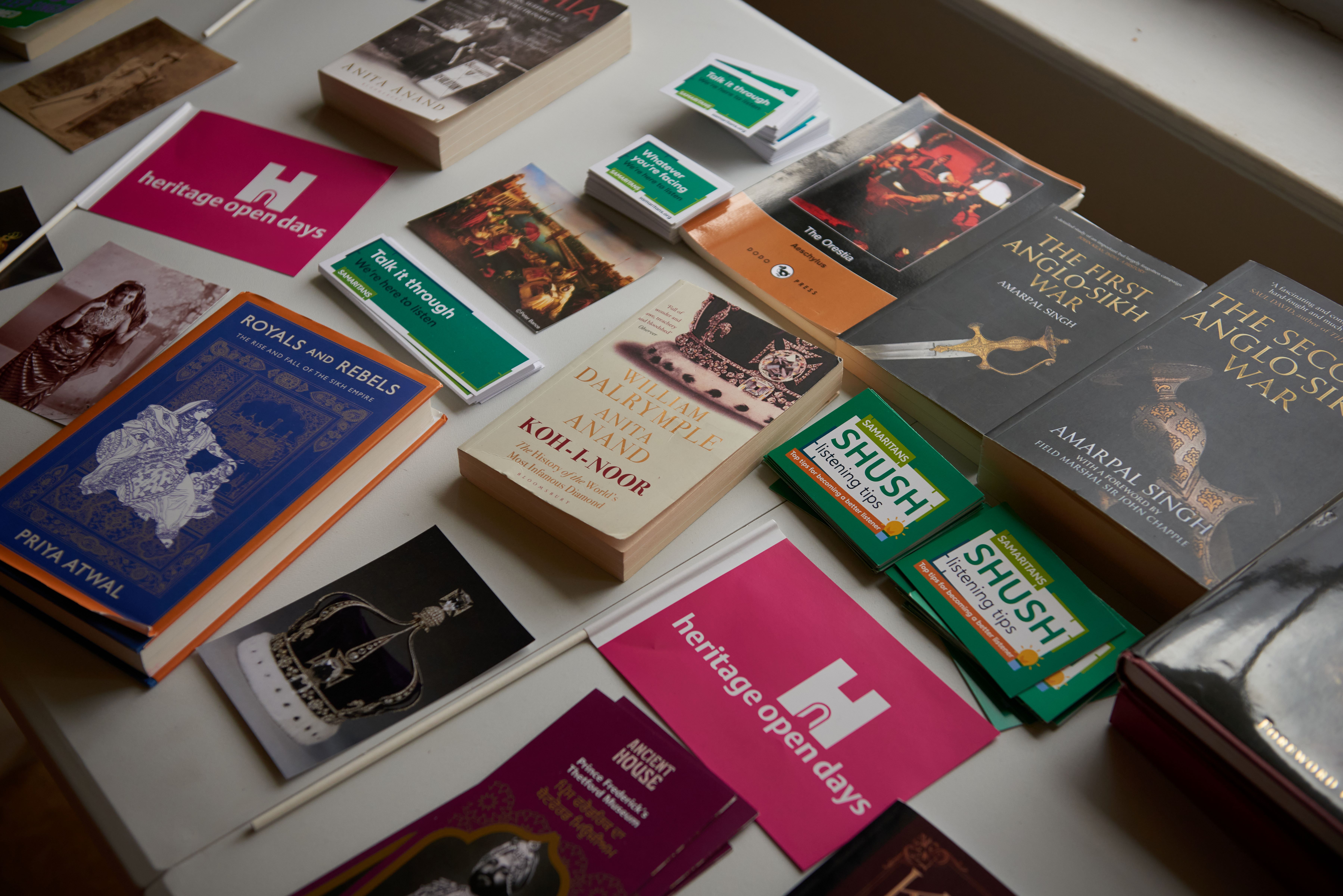 Books and leaflets laid out on a table.