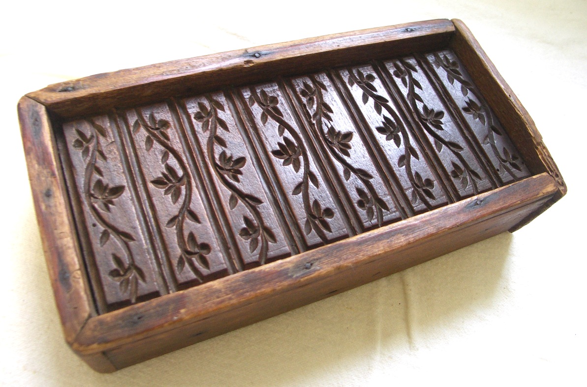 Rectangular wooden mould with leaf pattern in narrow segments.