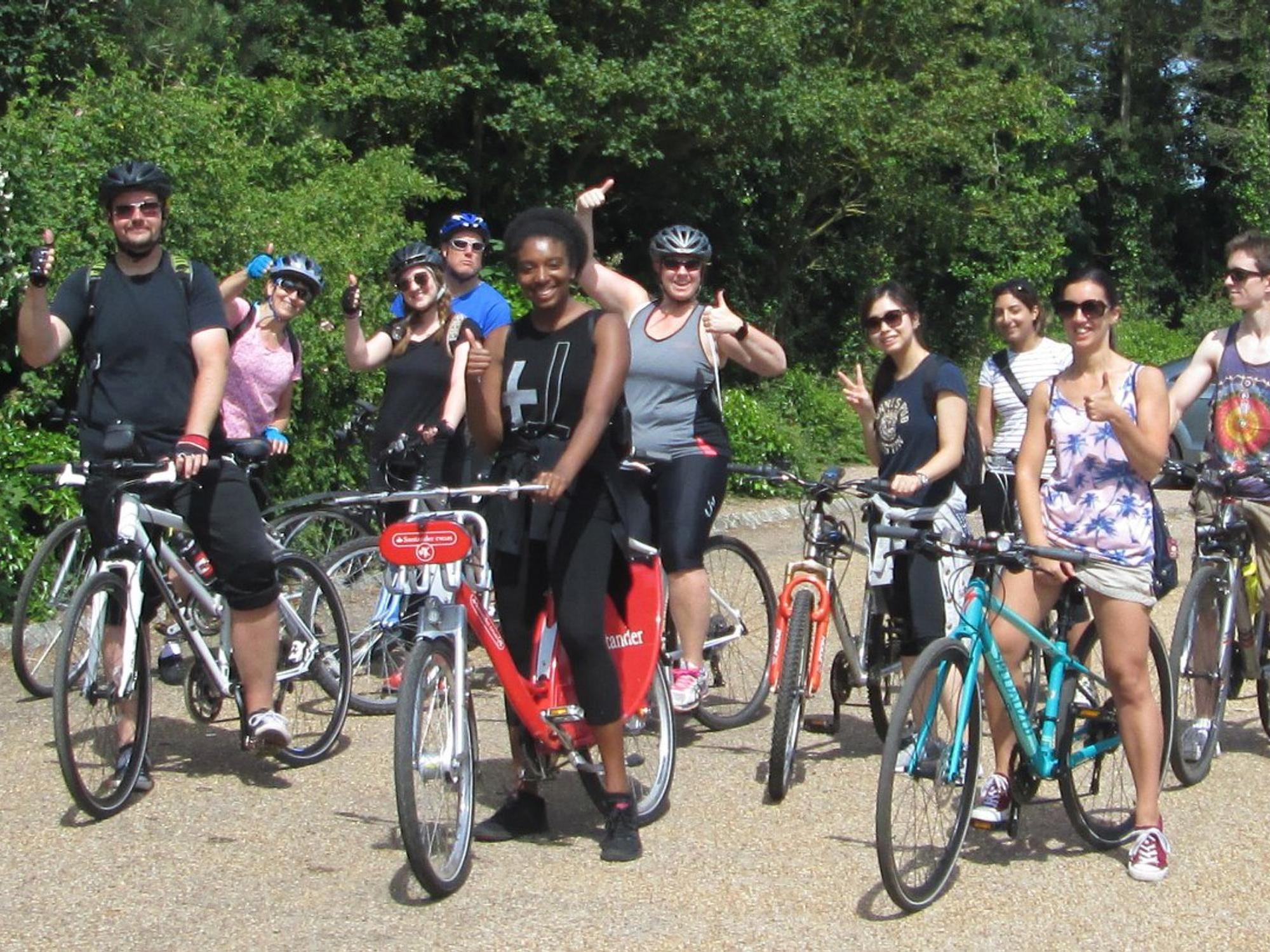 Large group of diverse people on bikes on a gravel path or road.
