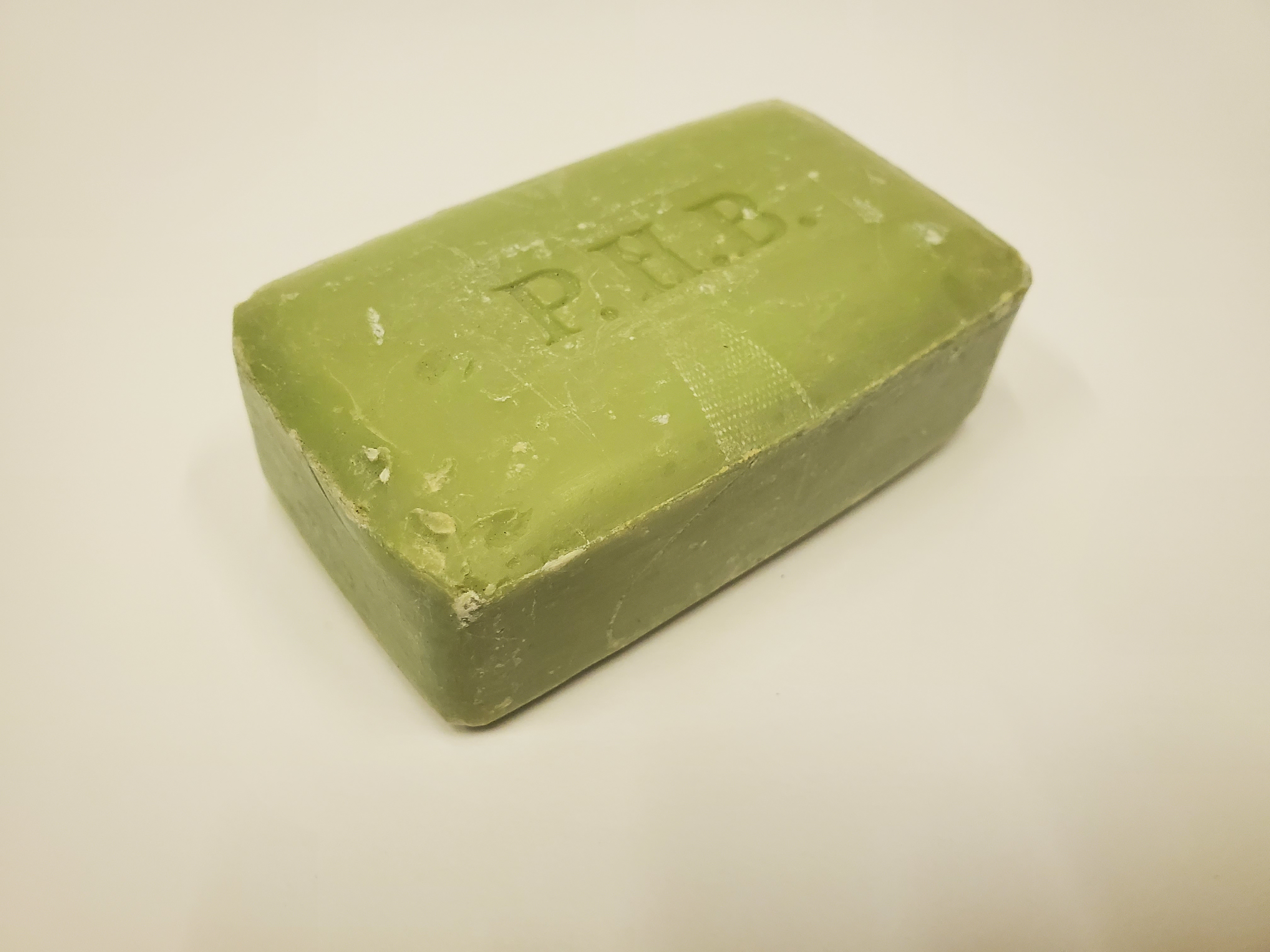 Bar of green soap with the letters PHB stamped in the centre.