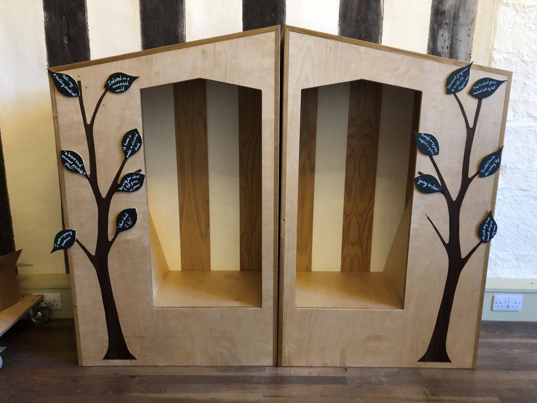 A pair of wooden cubbies, decorated by leaves.