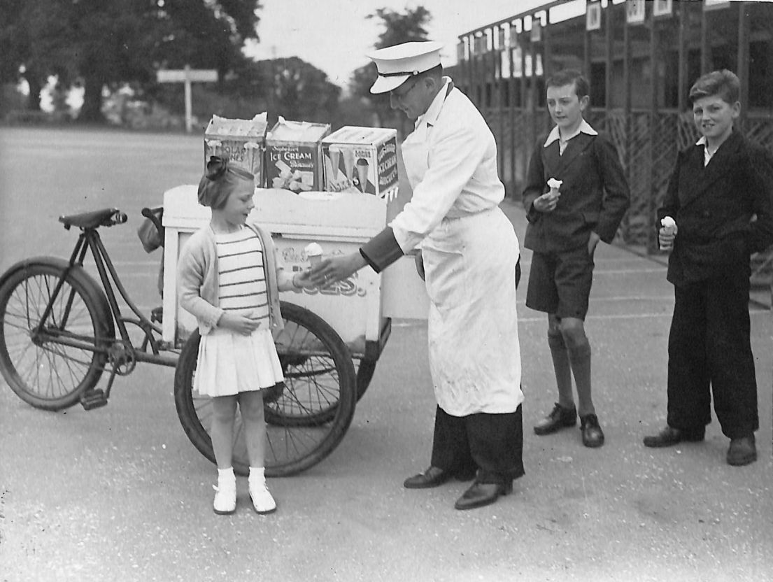 Old photo of ice cream vendor serving a small girl