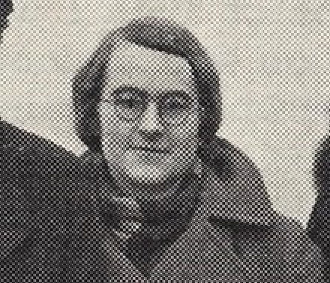 A cropped black and white image of a women wearing a coat. Her hair is in a short styled bob and wearing round glasses.
