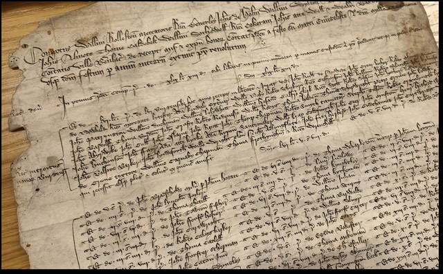Old piece of parchment covered in small black script.