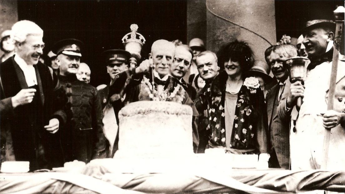 A black and white images showing the Mayor of Mansfield cutting open a very large pastry gooseberry pie!