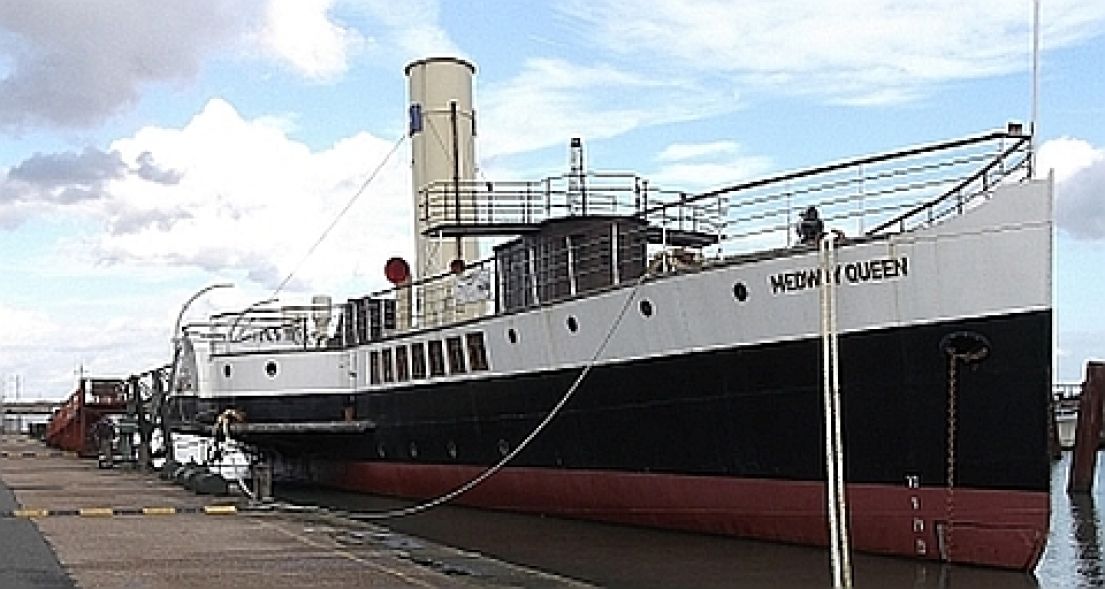 A 180ft steam paddle ship, the Medway Queen. The ships hull is pained red, black and white.