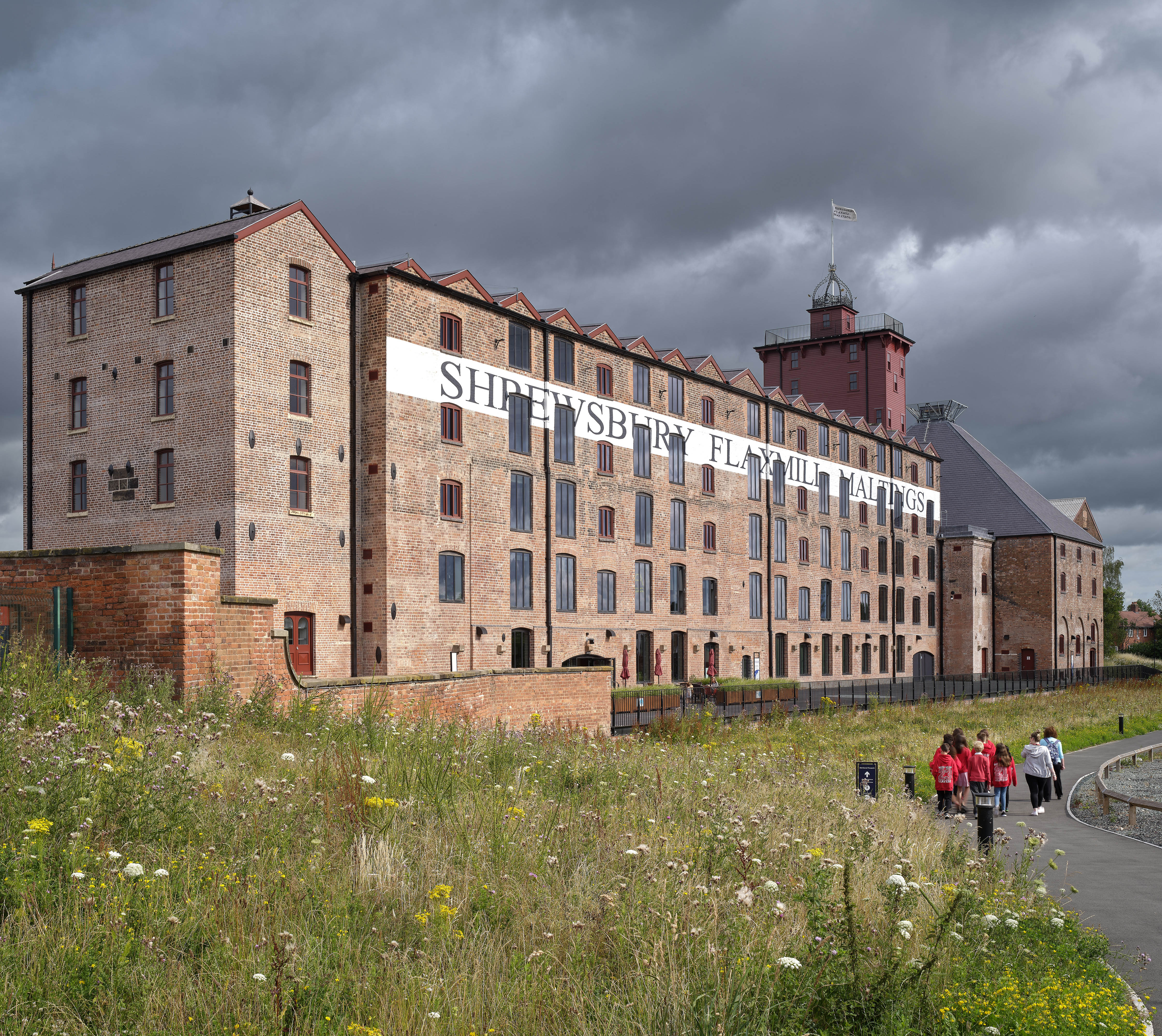 Large four story brick building with lots of windows.