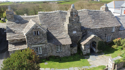 Aerial photograph of a rambling stone building with a wonky roofline