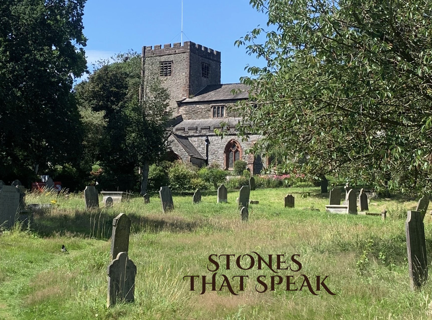 Square towered church in a grassy graveyard.