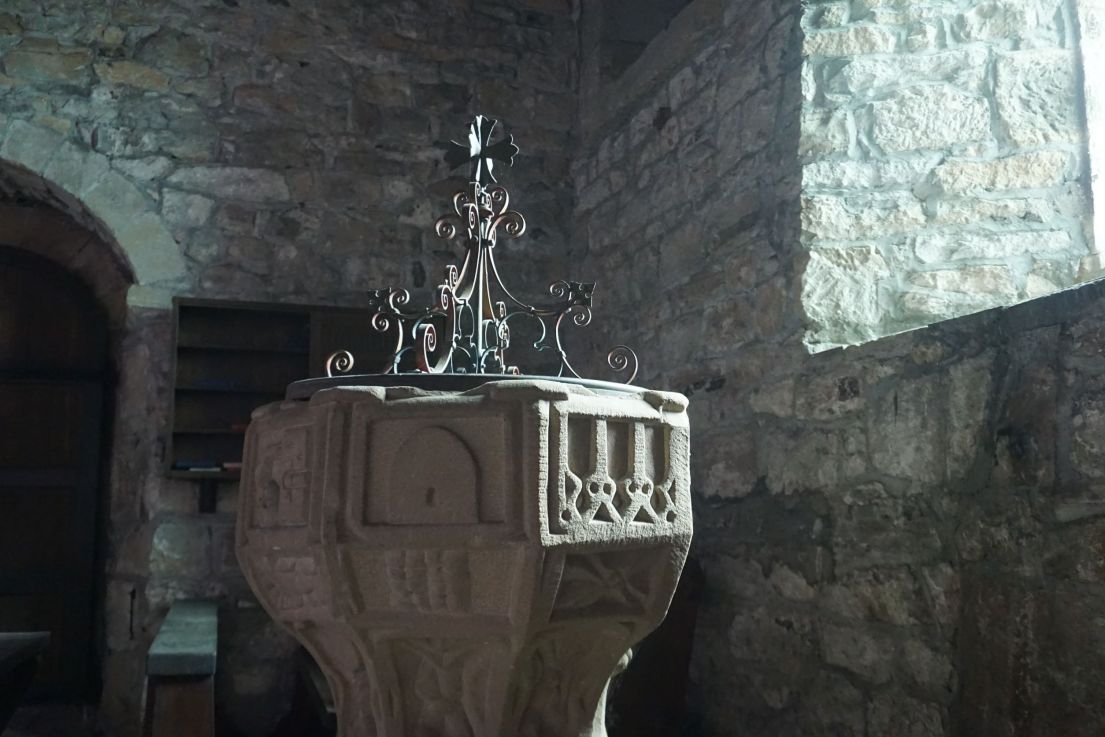A decorated carved stone font in a church.