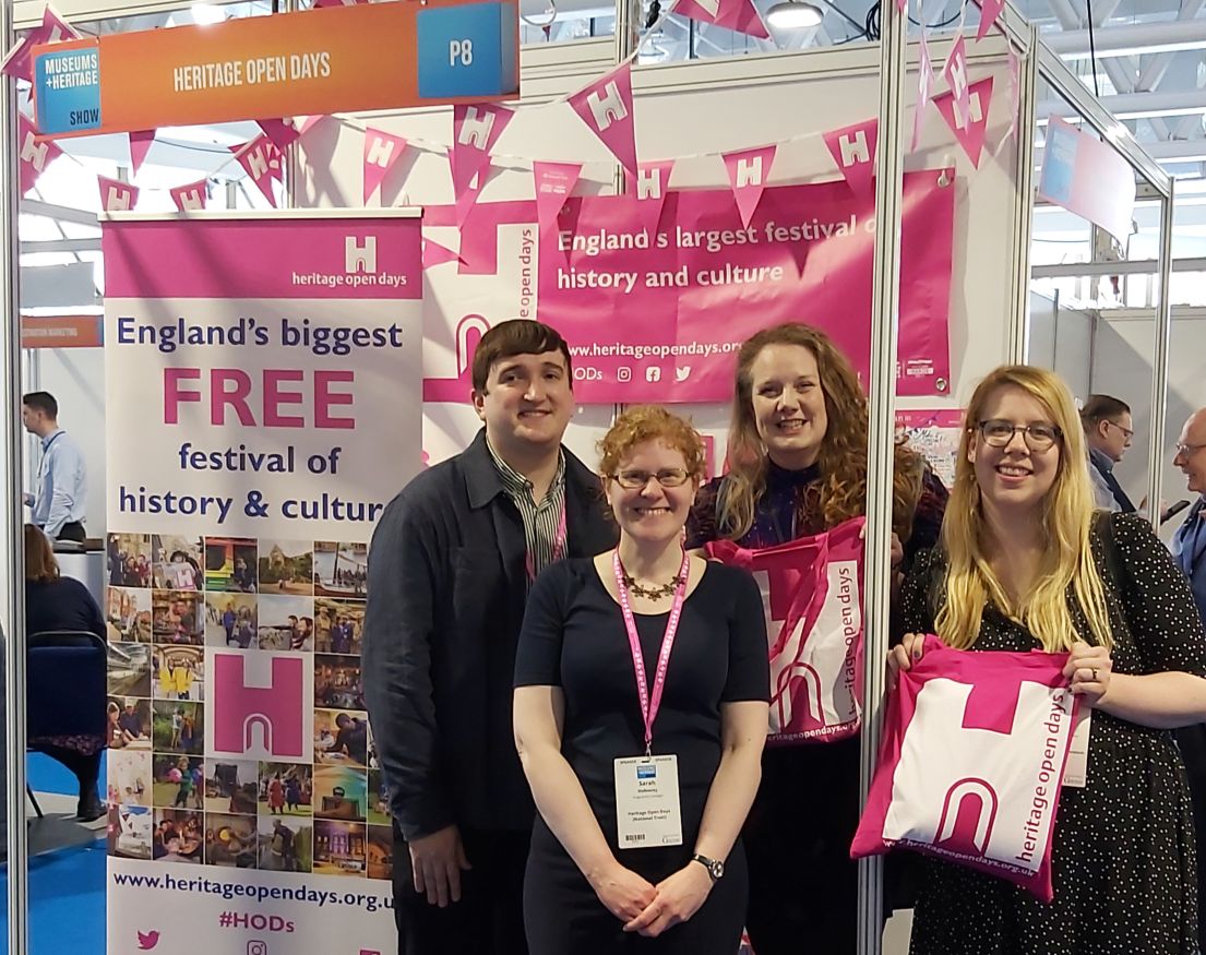 Four people stood in front of a tradestand with pink branding.